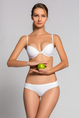 Beautiful woman body and green apple. Conceptual image of dieting healthy lifestyle