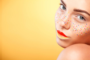 Portrait of bright beautiful girl with art colorful freckles make-up