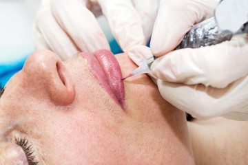 Lip tattoo woman in a beauty salon process