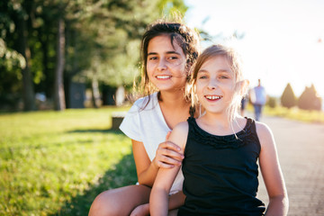 Obraz premium Two girls smiling together in a park