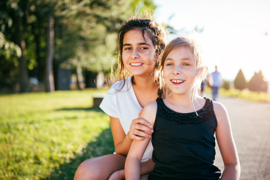 Two girls smiling together in a park