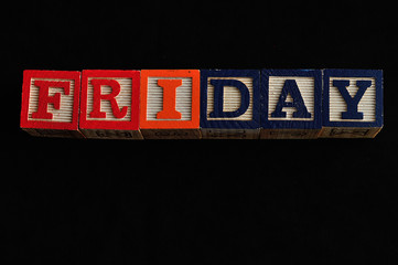 Friday spelled with Alphabet blocks isolated against a black background