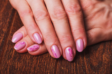 Light pink nail art on wooden background