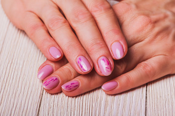 Light pink nail art on wooden background