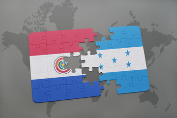 puzzle with the national flag of paraguay and honduras on a world map background.