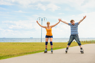 Young couple on roller skates riding outdoors
