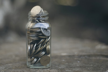 Coins in a jar on the stump.
