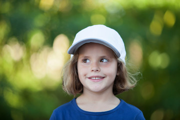 Little cute girl with a cap in the park