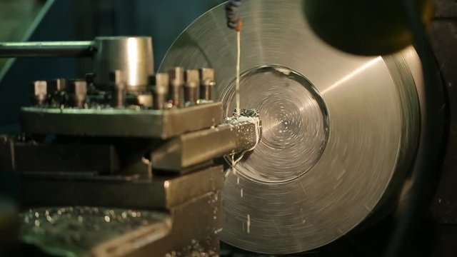 Operator of milling machine, controls flow of lubricating coolant on a running equipment.