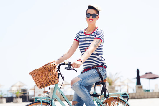 A picture of stylish young girl riding a bicycle in the city.