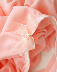 Pink bow on pink fabric dress for background