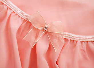 Obraz na płótnie Canvas Pink bow on pink fabric dress for background