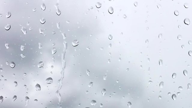 raindrop on window, grey sky background