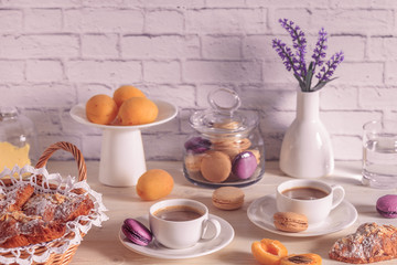 Breakfast with various macaroons, croissants and hot chocolate.