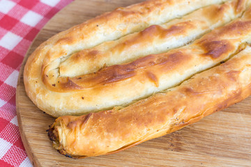 Round domestic burek pie with meat on the wooden board