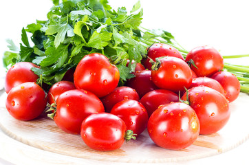 group of red ripe tomatoes and parsley on a wooden board