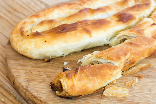 Rustic homemade burek pie with meat on the wooden background