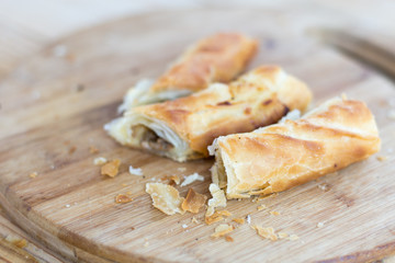 Burek with meat on the round wooden board
