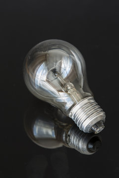 Classic light bulb with its reflection.
