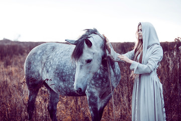 girl in the hooded cloak with horse, effect of toning