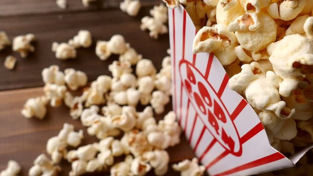 4K: Popcorn Spins Into Frame On Wooden Background