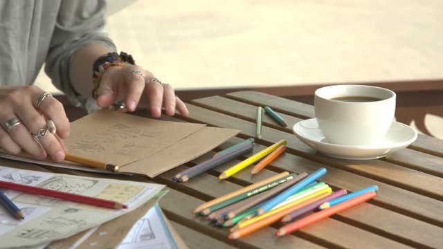 It is close-up image of female artist drawing picture with pencil