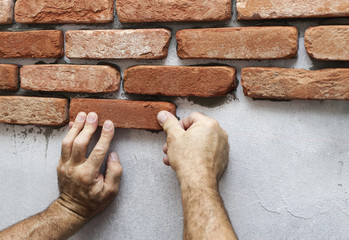 Wall facing work with brick by professional bricklayer worker