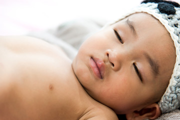 Fototapeta na wymiar Asian baby boy sleep on the bed , white background