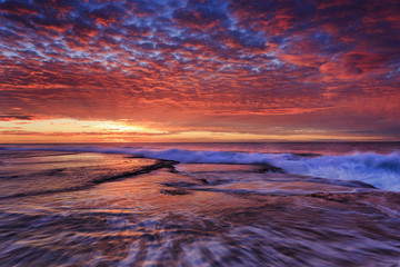 Sea mona vale pink sun over rockbed
