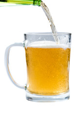 glass of light beer pouring from bottle on a white background