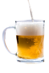 glass of light beer pouring from bottle on a white background