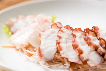 Fototapeta na wymiar Fresh cold Octopus sashimi in plate on wood table