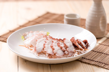 Fresh cold Octopus sashimi in plate on wood table