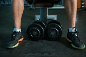 Legs and dumbbells in gym