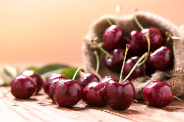 Cherries on wooden table with water drops macro background