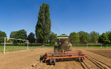 Tractor  con rastrillo despedregador para separar o quitar las piedras de la tierra. Construccion de un campo de futbol  © Siur