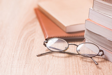 book and glasses on wood table