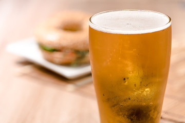 beer in glass and burger on wood table