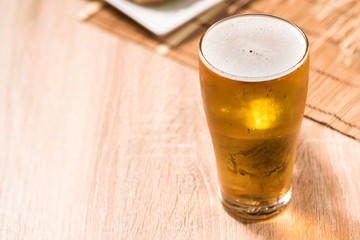 beer in glass and burger on wood table