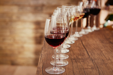 Many glasses of different wine in a row on bar counter