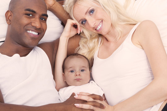 Cheerful interracial family cuddling