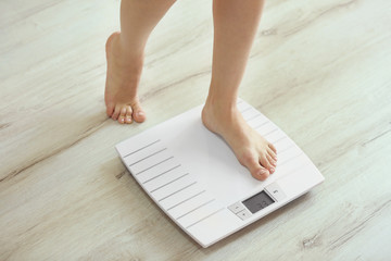 Female leg stepping on floor scales