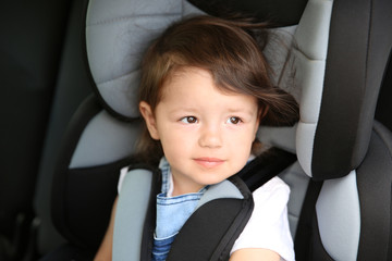 Boy sitting in a car in safety chair