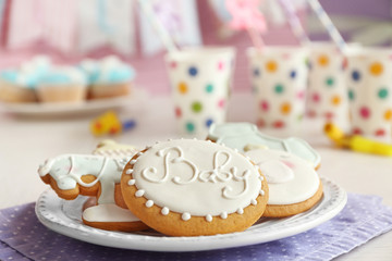 Baby glazed cookies in plate on decorated table