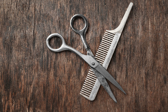 Vintage scissors and comb on wooden background