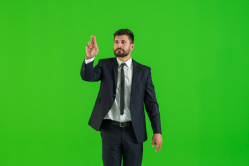 The businessman touch the virtual screen on the green background