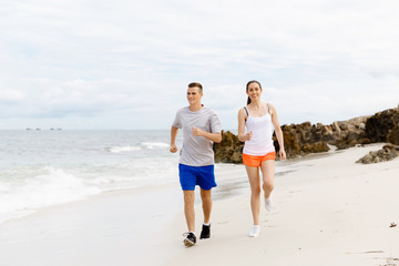 Fototapeta premium Runners. Young couple running on beach