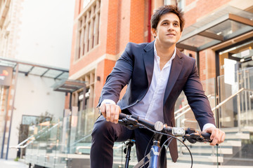 Successful businessman riding bicycle