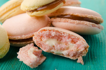 Sweet and colourful french macaroons on wood turquoise background