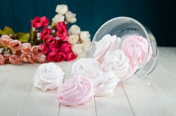 Zefir or marshmallow roses on a wooden stand as part of sweet dessert table or candy bar. Wedding party.